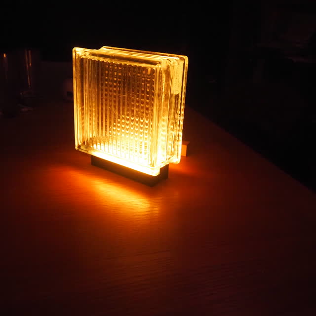 Amber lamp from above, light pooling on the table